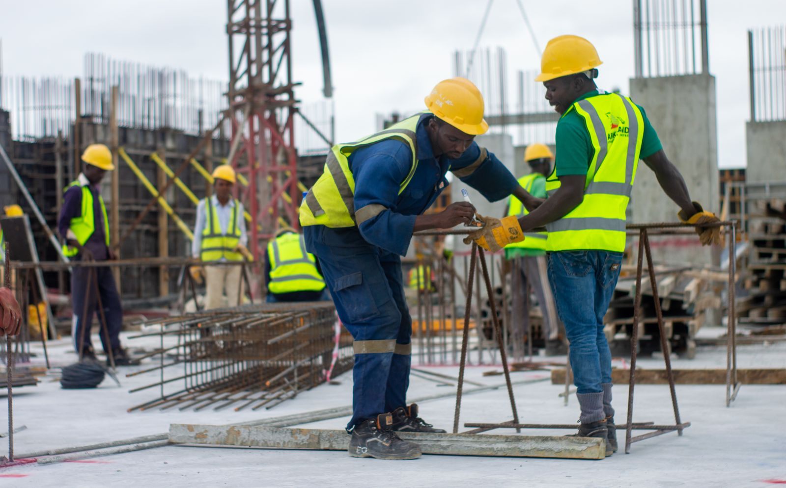 A diverse group of construction workers in safety gear at an active building site