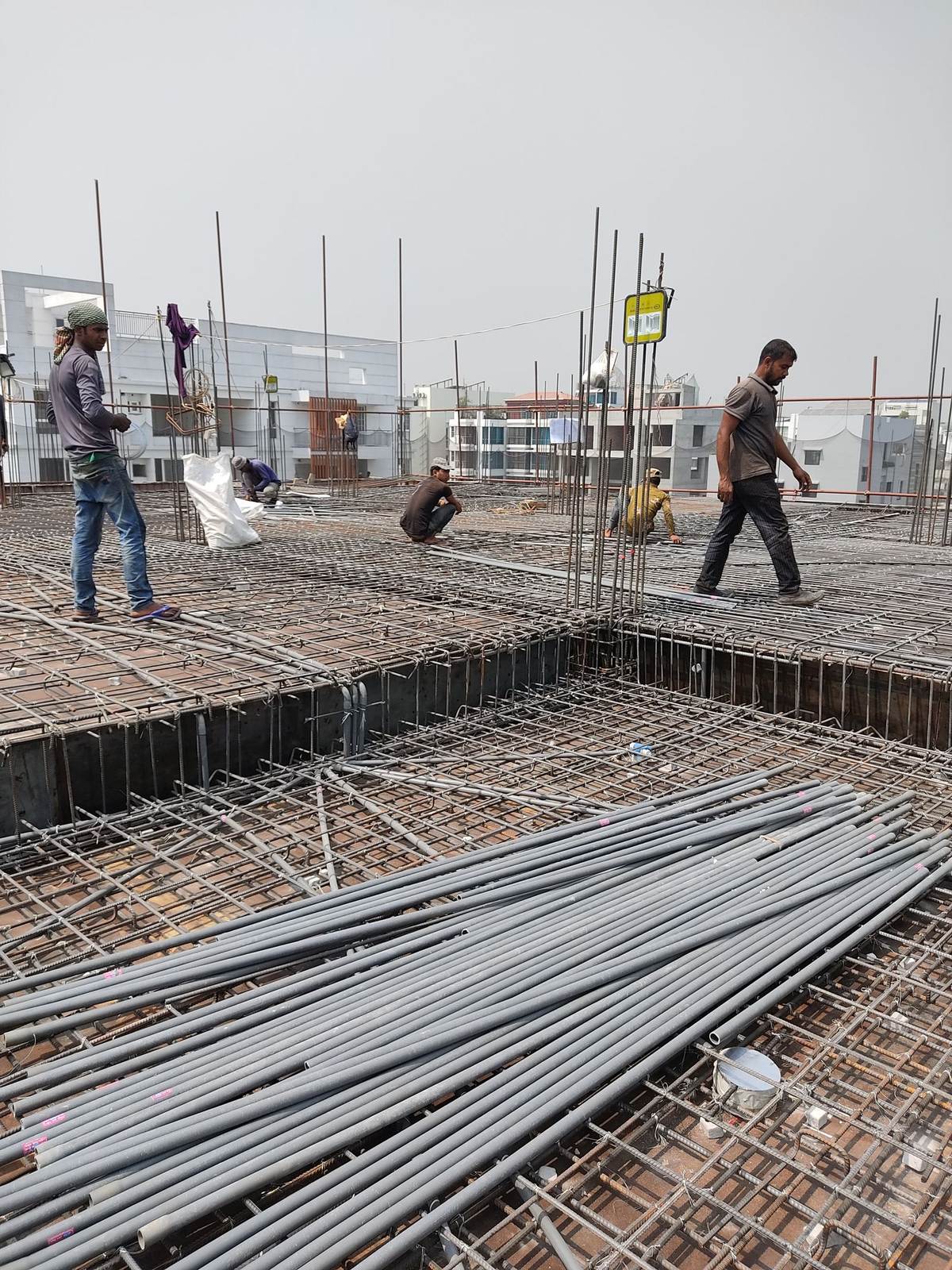 Workers engaged in construction on a building site, laying metal frameworks